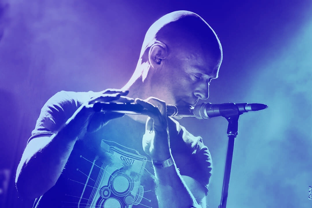 Brian, in a moody concert shot, playing his Flute into the microphone