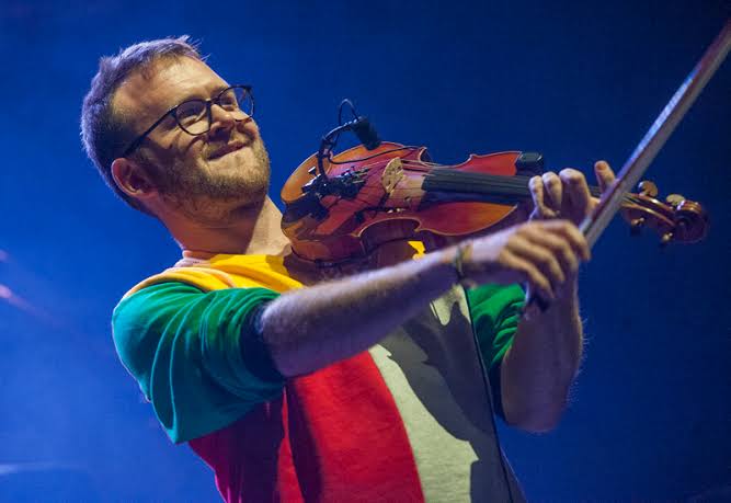 Sam, on stage in concert with his fiddle, paused playing and pointing his bow into the audience